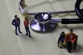 Miniature people sitting and stethoscope. Family parent, healthcare, medical concept