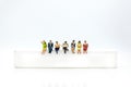 Miniature people, sitting on white block. White block can write anything for various occasions Royalty Free Stock Photo