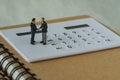 Miniature people: Small figure businessmen handshaking and stand Royalty Free Stock Photo