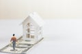 Miniature people small figure walking on hundred dollar banknote to Model white house. Property investment Royalty Free Stock Photo