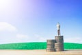 Miniature people small figures businessman stand on money of coin stack step up growing growth on blue sky and white cloud. Royalty Free Stock Photo