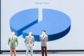 Miniature people : small figures businessmen stand with graph ma