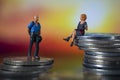 Miniature people, small figures businessmen and woman on top of coins. Money and Financial, Business Growth concept. Macro Royalty Free Stock Photo