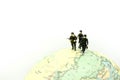 Miniature people : soldiers team with world map,War, army, military, guard concept. Royalty Free Stock Photo