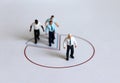 Miniature people standing on a circle graph.