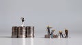 Miniature people standing on a pile of coins. A concept of income inequality. Royalty Free Stock Photo