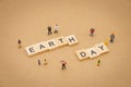 Miniature people standing with wood word Earth Day using as background Universal day concept and Earth Day concept with copy space Royalty Free Stock Photo