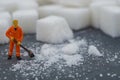Miniature people sweep up sugar. Health care concept.
