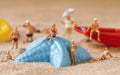 Miniature people in swimsuit on the beach