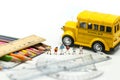 Miniature people : teacher and student with colorful drawing tools and stationary of school bus,education concept Royalty Free Stock Photo