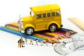 Miniature people : teacher and student with colorful drawing tools and stationary of school bus,education concept Royalty Free Stock Photo