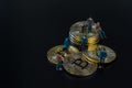 Miniature people teamworks, small model human figure standing and sitting on golden Bitcoins stack with copyspace for your text. Royalty Free Stock Photo
