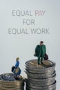 Miniature people and text equal pay for equal work Royalty Free Stock Photo