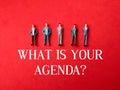 Miniature people with text WHAT IS YOUR AGENDA on a red background Royalty Free Stock Photo