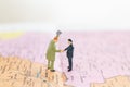 Miniature people : Tourist handshake on world map background Royalty Free Stock Photo