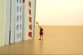 Miniature people toy figure photography. Bookshelf library concept. A girl returning a book