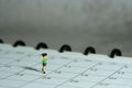 Miniature people toy figure photography. A boy running above monthly planner calendar. Grey cloudy background Royalty Free Stock Photo