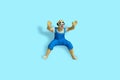 Miniature people toy figure photography. Front view of bald clown wearing blue dress on blue background