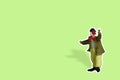 Miniature people toy figure photography. Full body of a clown wearing huge bowties sticker on green background