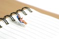 Miniature people toy figure photography. Girl relaxing seat at beach chair while reading book