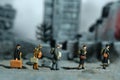 Miniature people toy figure photography. A group of refugee walking, moving in the middle of ruined demolish city, because of war