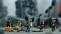 Miniature people toy figure photography. A group of refugee walking, moving in the middle of ruined destroyed building, demolish