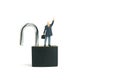 Miniature people toy figure photography. Idea creativity unlock concept. A businessman standing above closed padlock while raise