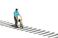 Miniature people toy figure photography. Learning road traffic sign concept. A father and son walking on crosswalk. white