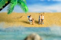 Miniature people toy figure photography. Men and girl couple relaxing on beach chair when daylight at seaside Royalty Free Stock Photo