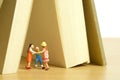 Miniature people toy figure photography. Play tent at home. Kids playing together bellow book