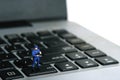 Miniature people toy figure photography. Web data privacy concept. A security officer standing above notebook laptop. Isolated on Royalty Free Stock Photo