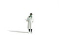 Miniature people toy figure photography. A women doctor wearing coat standing with handing medical checkup document, isolated on Royalty Free Stock Photo