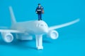 Miniature people toys conceptual photography. Airplane parcel package delivery. Postman courier with white plane