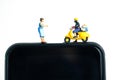 Miniature people toys conceptual photography. Mobile post service delivery. Postman courier standing above smartphone, isolated on