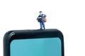 Miniature people toys conceptual photography. Mobile post service delivery. Postman courier standing above smartphone, isolated on