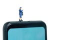 Miniature people toys conceptual photography. Mobile post service delivery. Postman courier standing above smartphone, isolated on