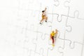 Miniature people : Traveler, climber on jigsaw board. Image use for to solve problems, finding solution and think new idea concept Royalty Free Stock Photo