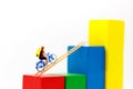 Miniature people: Traveler riding bicycle on wood ladder