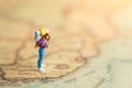 Miniature people: traveler walking on the map. Used to travel to destinations on travel business background concept Royalty Free Stock Photo