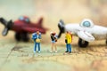 Miniature people: travelers with backpack standing on world map travel by plane. Image use for travel business concept Royalty Free Stock Photo