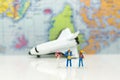 Miniature people: travelers with backpack standing on world map travel by plane. Image use for travel business concept Royalty Free Stock Photo