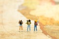 Miniature people: travelers with backpack standing on world map, walking to destination. Image use for travel business concept Royalty Free Stock Photo