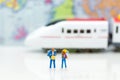 Miniature people: travelers with backpack waiting for train. Image use for travel business concept.