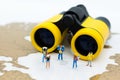 Miniature people: Travelers standing on a world map with binoculars. Image use for travel , business concept Royalty Free Stock Photo