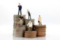 Miniature people with various occupations standing on coins money Royalty Free Stock Photo