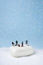 Miniature people on the white soap working on snow