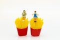 Miniature people : Woman sitting on junkfood. Image use for healthcare and diet concept