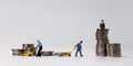 Miniature people at work site with stack coins. Concept of economic inequality.