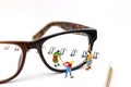 Miniature people worker cleaning eyes glasses on book. Clear Vision concept. Royalty Free Stock Photo