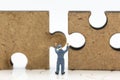 Miniature people : Worker pushing back jigsaw puzzle pieces . Image use for solve, finding solution, business vision concept Royalty Free Stock Photo